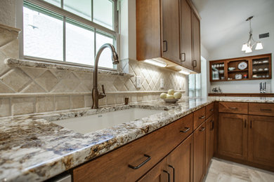Inspiration for a mid-sized craftsman u-shaped porcelain tile and beige floor eat-in kitchen remodel in Dallas with an undermount sink, shaker cabinets, medium tone wood cabinets, granite countertops, beige backsplash, stone tile backsplash, stainless steel appliances and a peninsula