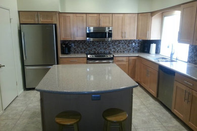Inspiration for a mid-sized contemporary l-shaped open concept kitchen remodel in Phoenix with a double-bowl sink, shaker cabinets, light wood cabinets, granite countertops, blue backsplash, stainless steel appliances and an island