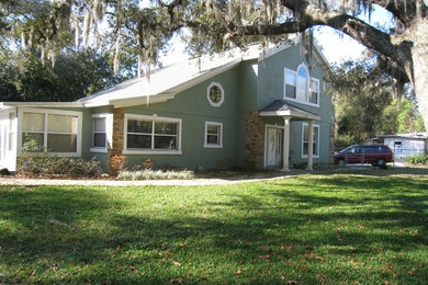This is an example of a mid-sized transitional two-storey stucco green exterior in Orlando.