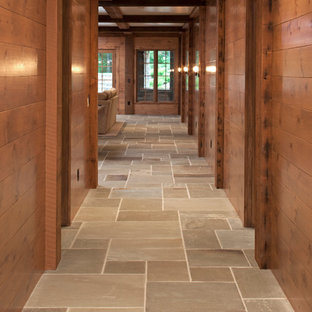 Rustic walk-out basement in Minneapolis with brown walls and slate flooring.
