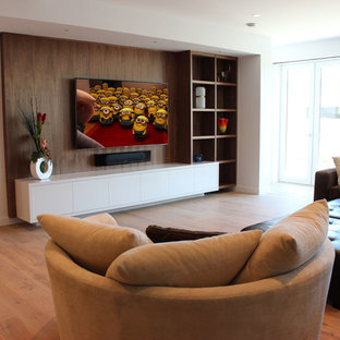 Aménagement d'une salle de cinéma contemporaine de taille moyenne et ouverte avec un mur blanc, un sol en bois clair, un téléviseur fixé au mur et un sol beige.