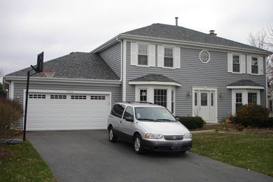 Large traditional gray two-story vinyl exterior home idea in Chicago with a hip roof
