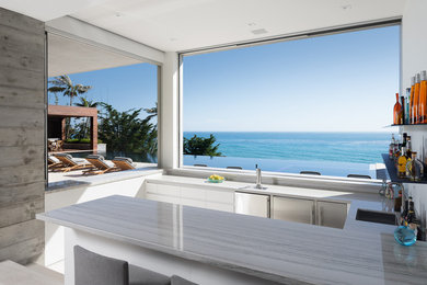 Example of a beach style home bar design in Los Angeles with quartzite countertops