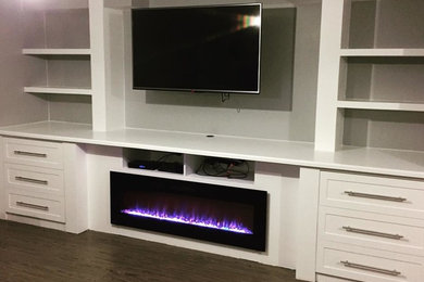 Mid-sized trendy underground vinyl floor basement photo in Calgary with gray walls, a standard fireplace and a wood fireplace surround