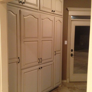 Inspiration pour une arrière-cuisine traditionnelle de taille moyenne avec un placard avec porte à panneau surélevé, des portes de placard blanches et un sol en travertin.