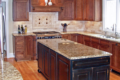 Large elegant u-shaped light wood floor eat-in kitchen photo in Charlotte with an undermount sink, recessed-panel cabinets, medium tone wood cabinets, granite countertops, beige backsplash, stone tile backsplash and stainless steel appliances