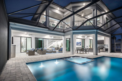 Example of a transitional backyard infinity pool design in Miami