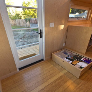 Inspiration for a small modern home studio in Los Angeles with white walls, bamboo floors and a freestanding desk.