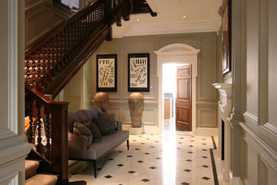 This is an example of a large traditional hallway in London with grey walls and marble floors.