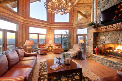 Inspiration for a rustic living room remodel in Atlanta with a standard fireplace, a stone fireplace and a wall-mounted tv