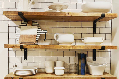 Country kitchen photo in Other with flat-panel cabinets, white cabinets, wood countertops, stainless steel appliances, an island, white backsplash and glass tile backsplash