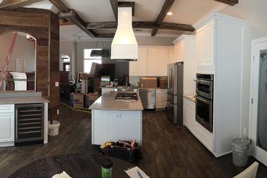 Large transitional l-shaped dark wood floor and brown floor enclosed kitchen photo in Tampa with raised-panel cabinets, white cabinets, stainless steel appliances and an island