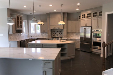 Example of a large classic galley porcelain tile and gray floor eat-in kitchen design in DC Metro with an undermount sink, flat-panel cabinets, gray cabinets, solid surface countertops, gray backsplash, marble backsplash, stainless steel appliances, two islands and white countertops