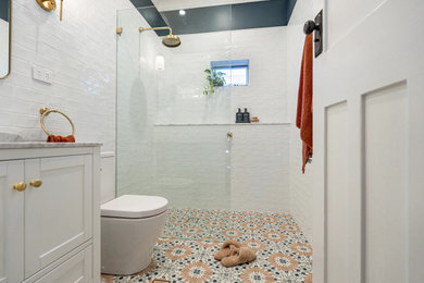 Mid-sized 3/4 bathroom in Sydney with shaker cabinets, white cabinets, an open shower, a two-piece toilet, white tile, blue walls, an undermount sink, marble benchtops, multi-coloured floor, an open shower, grey benchtops, a single vanity and a freestanding vanity.