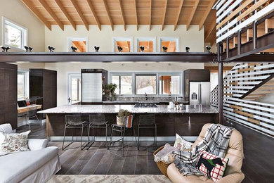 Inspiration for a large cottage galley ceramic tile open concept kitchen remodel in Detroit with an undermount sink, flat-panel cabinets, dark wood cabinets, granite countertops, stainless steel appliances and an island