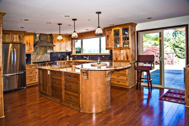 Kitchen - traditional medium tone wood floor and brown floor kitchen idea in Portland with an undermount sink, shaker cabinets, light wood cabinets, granite countertops, blue backsplash, stone slab backsplash and stainless steel appliances