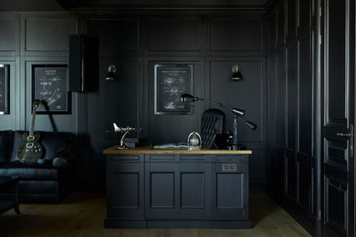 Photo of a traditional study room in Moscow with black walls, a freestanding desk, light hardwood floors and beige floor.