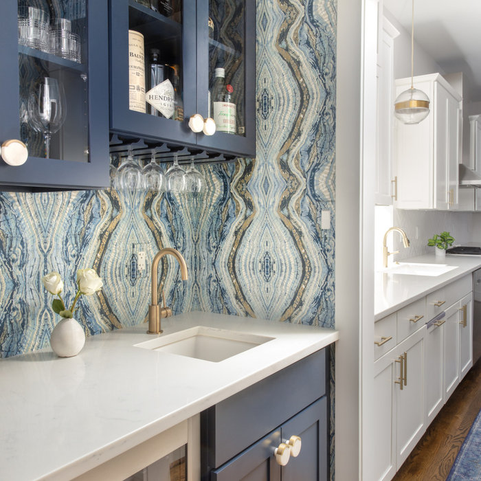 Who's ready for a cocktail? This Butler's Pantry was craving color! We gave it a luxe makeover with navy cabinetry, quartz countertops, and amazing dramatic wallpaper. The marble and brass cabinet kno