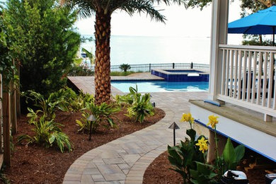 Photo of a tropical side yard full sun garden in Miami with concrete pavers.