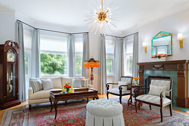 Mid-sized elegant formal and enclosed medium tone wood floor and brown floor living room photo in New York with blue walls, a standard fireplace, a stone fireplace and no tv