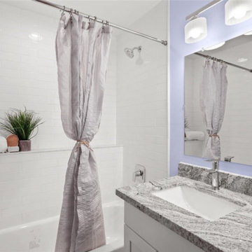 White subway 2x8'' tile shower with marble pencil border and shelf.