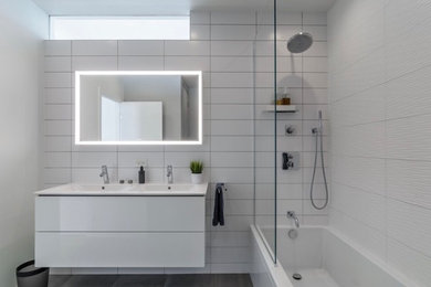 Inspiration for a modern master white tile and porcelain tile cement tile floor and gray floor bathroom remodel in Chicago with flat-panel cabinets, white cabinets, a wall-mount toilet, white walls, a hinged shower door and white countertops