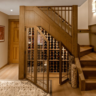 Bild på en liten vintage vinkällare, med vinhyllor, ljust trägolv och brunt golv