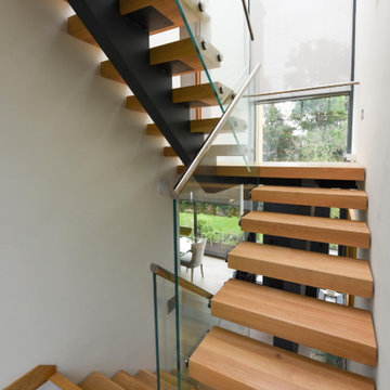Central stringer oak & metal staircase with glass balustrade