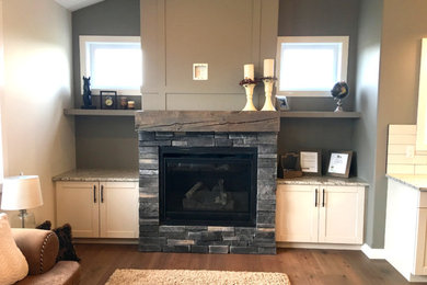 Inspiration for a mid-sized craftsman open concept medium tone wood floor and brown floor living room remodel in Edmonton with beige walls, a standard fireplace and a stone fireplace