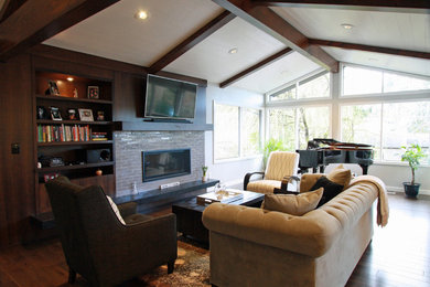 Example of a mid-sized trendy open concept dark wood floor and brown floor living room design in Portland with gray walls, a standard fireplace, a tile fireplace and a media wall