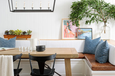 This is an example of a mid-sized transitional dining room in San Francisco with white walls, medium hardwood floors, brown floor and planked wall panelling.