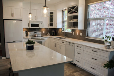 Open concept kitchen - large contemporary l-shaped ceramic tile and beige floor open concept kitchen idea in Vancouver with an undermount sink, shaker cabinets, white cabinets, quartz countertops, gray backsplash, subway tile backsplash, white appliances, an island and white countertops