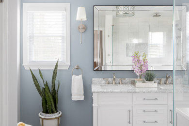 Transitional double-sink walk-in shower photo in New York with white cabinets, an undermount sink, a hinged shower door and a freestanding vanity
