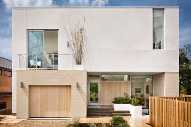 Design ideas for a modern two-storey white exterior in Austin with a flat roof.