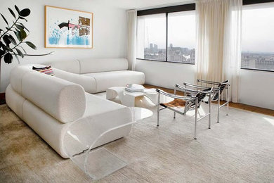 Example of a mid-sized trendy open concept medium tone wood floor and brown floor living room design in New York with white walls and no fireplace