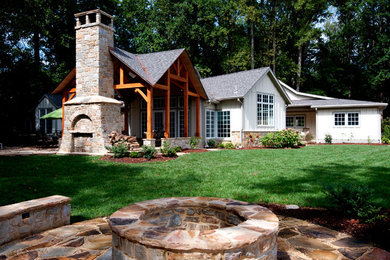 Design ideas for a large country backyard patio in Baltimore with a fire feature, natural stone pavers and a roof extension.