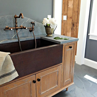Photo of a medium sized traditional single-wall utility room in New York with a belfast sink, beaded cabinets, soapstone worktops, grey walls, slate flooring, grey worktops and medium wood cabinets.