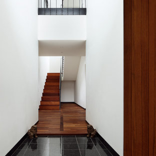 大阪の片開きドアモダンスタイルのおしゃれな玄関ホール (白い壁、大理石の床、木目調のドア、黒い床) の写真