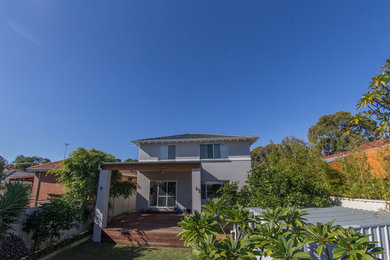 This is an example of a mid-sized contemporary two-storey stucco brown house exterior in Perth with a hip roof and a tile roof.