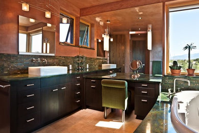 Mid-sized trendy master green tile drop-in bathtub photo in Albuquerque with a vessel sink, flat-panel cabinets, black cabinets and brown walls