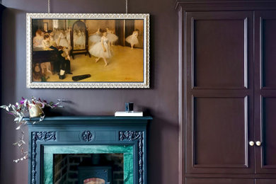 Cette image montre une grande chambre parentale traditionnelle avec un mur violet, un sol en bois brun, un poêle à bois, un manteau de cheminée en pierre, un sol beige et un plafond en papier peint.