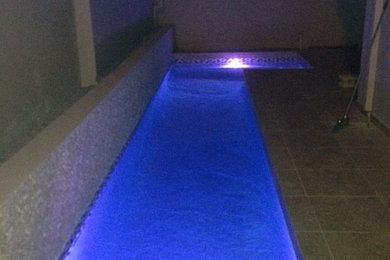 Pool - mid-sized modern side yard tile and l-shaped lap pool idea in Other