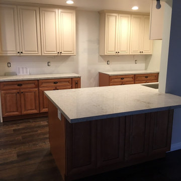 Antique white kitchen upper cabinet with cinnamon cabinets and Quartz countertop