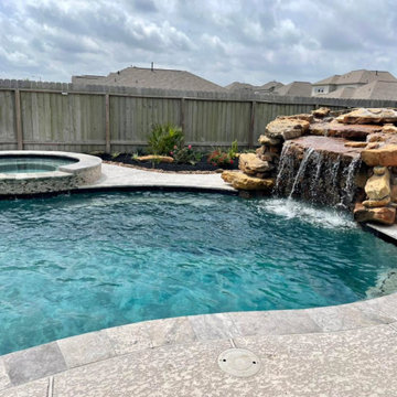Freeform Pool with Rock Waterfall and Round Raised Spa