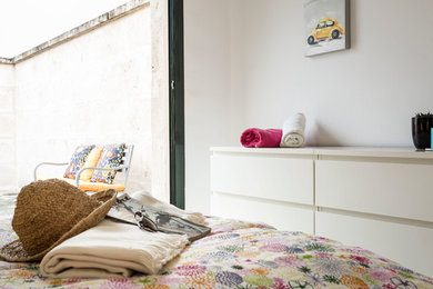 Modelo de dormitorio principal mediterráneo de tamaño medio sin chimenea con paredes blancas