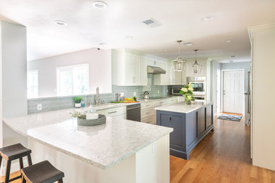Eat-in kitchen - large transitional u-shaped medium tone wood floor and brown floor eat-in kitchen idea in Boston with an undermount sink, shaker cabinets, white cabinets, quartz countertops, blue backsplash, glass tile backsplash, stainless steel appliances, an island and gray countertops