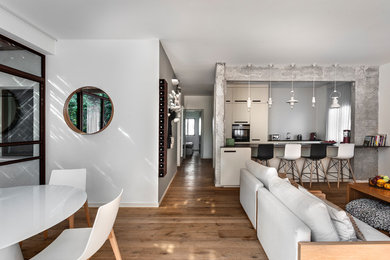 Trendy open concept medium tone wood floor and brown floor living room photo in Tel Aviv with gray walls