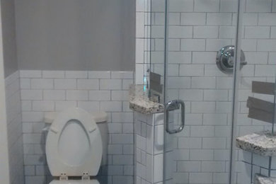 Alcove shower - mid-sized transitional white tile and subway tile slate floor alcove shower idea in Houston with shaker cabinets, white cabinets, a two-piece toilet, gray walls and granite countertops