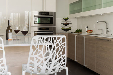 Inspiration for a contemporary l-shaped porcelain tile and gray floor eat-in kitchen remodel in Boston with flat-panel cabinets, quartz countertops, gray backsplash, glass tile backsplash, stainless steel appliances and a peninsula