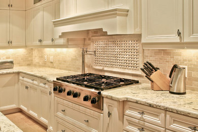 Large elegant l-shaped eat-in kitchen photo in Toronto with flat-panel cabinets, white cabinets, granite countertops, beige backsplash, stone tile backsplash, stainless steel appliances and an island